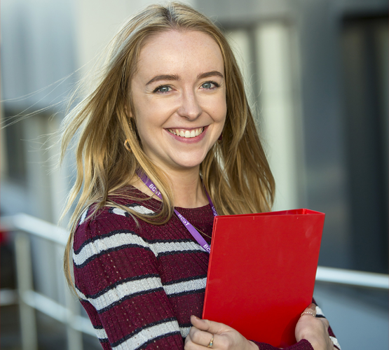 Smiling student holding documents