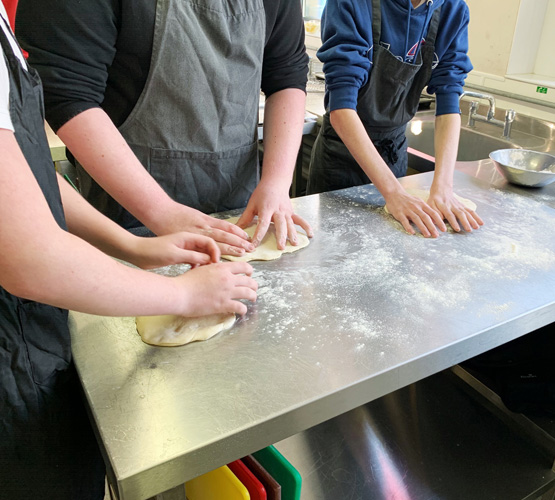 School students making pizza bases