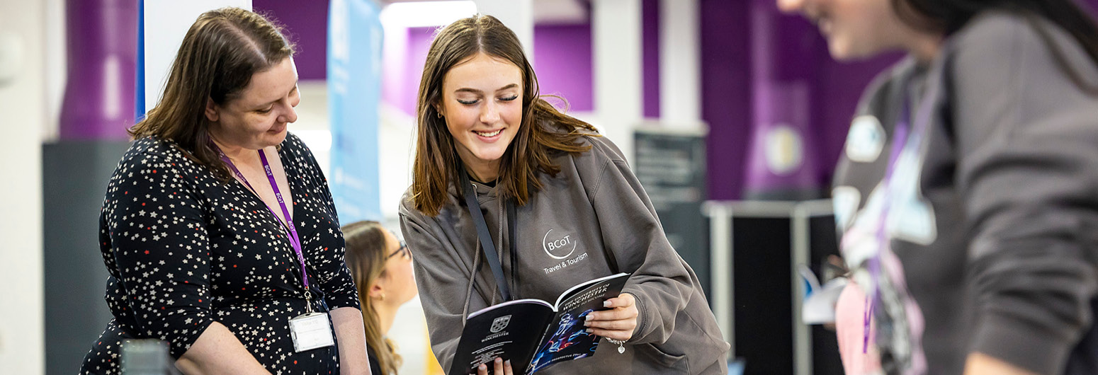 Students looking through guides at event stalls