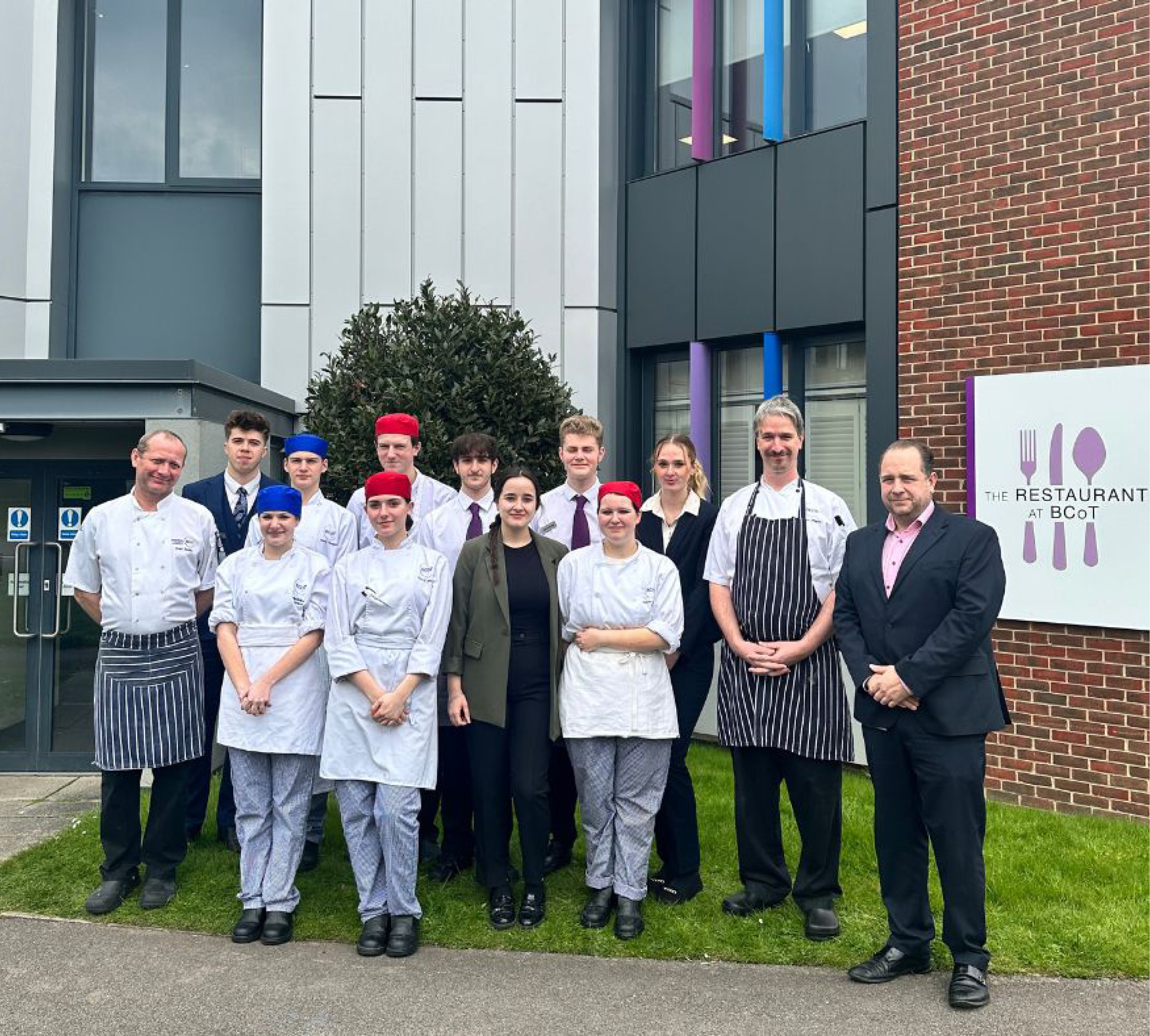 College hospitality staff and students posed outside restaurant