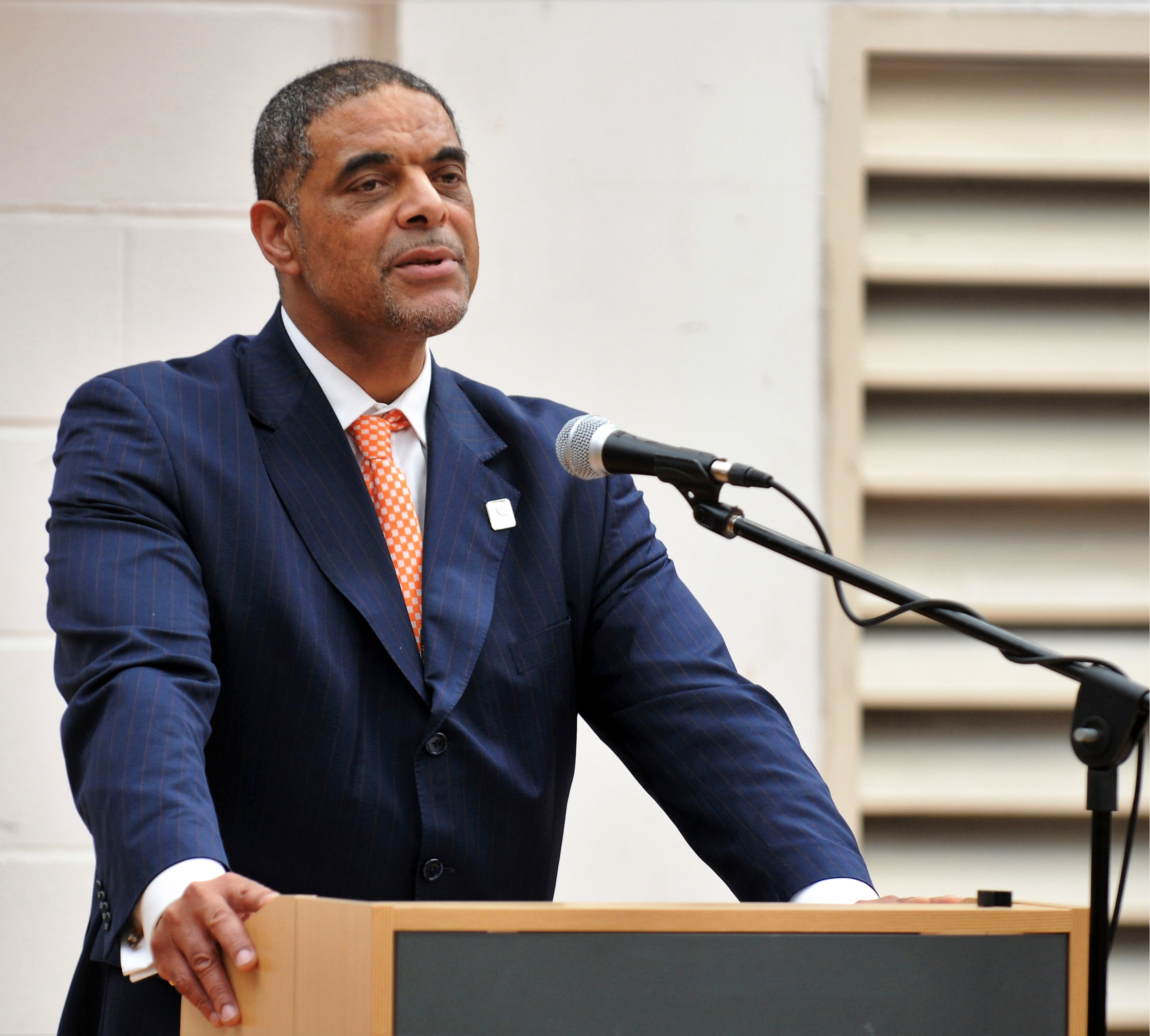 Principal Anthony Bravo speaking out to crowd with microphone